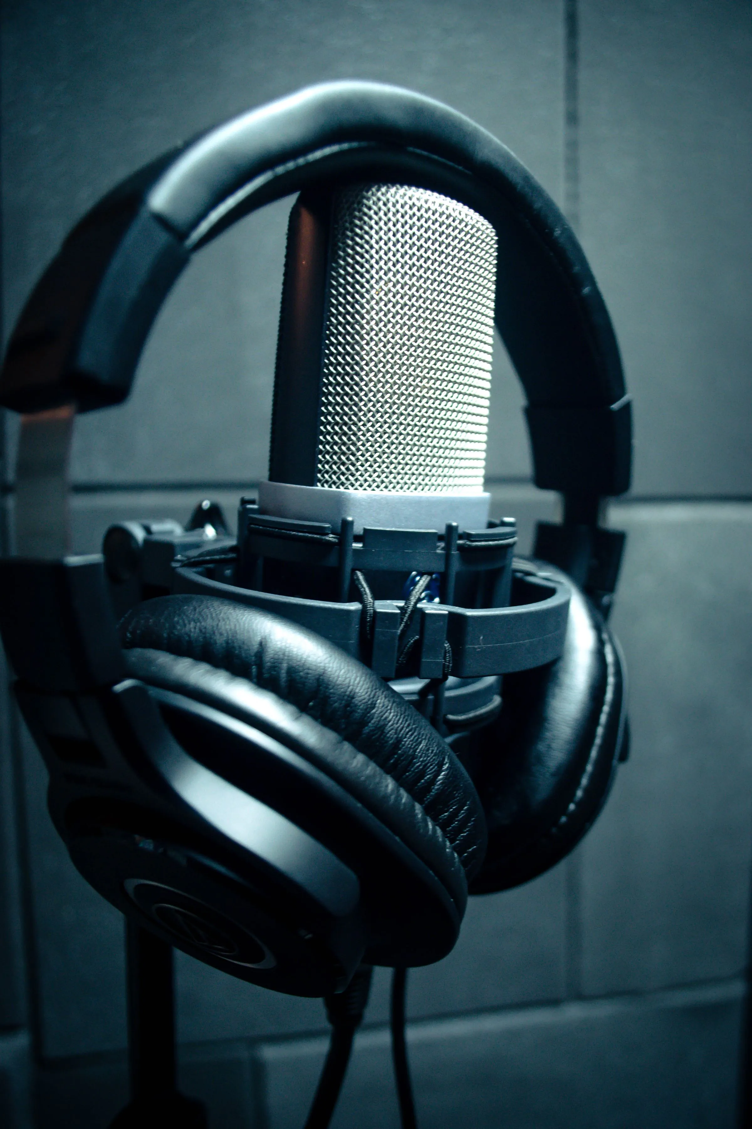 Close-up of condenser microphone with headphones in a music studio.